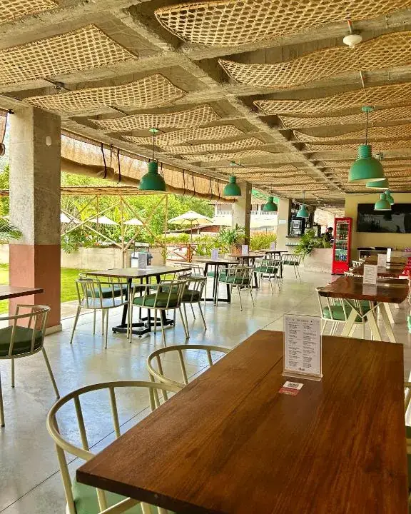 Mesas de madera y lámparas verdes en la terraza de Alaia Barra Comedor