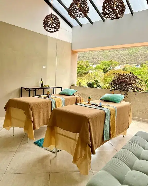 Dos camillas de masaje lado a lado en el spa, abierto al paisaje